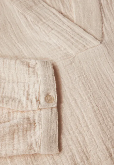 Beiges Hemd aus strukturiertem Stoff mit Knopfdetail.